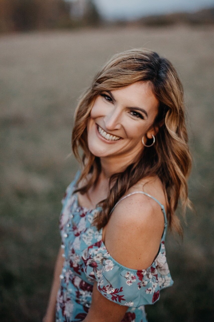 Allison Van Zanten, Central Oregon portrait photographer, smiling in a floral dress