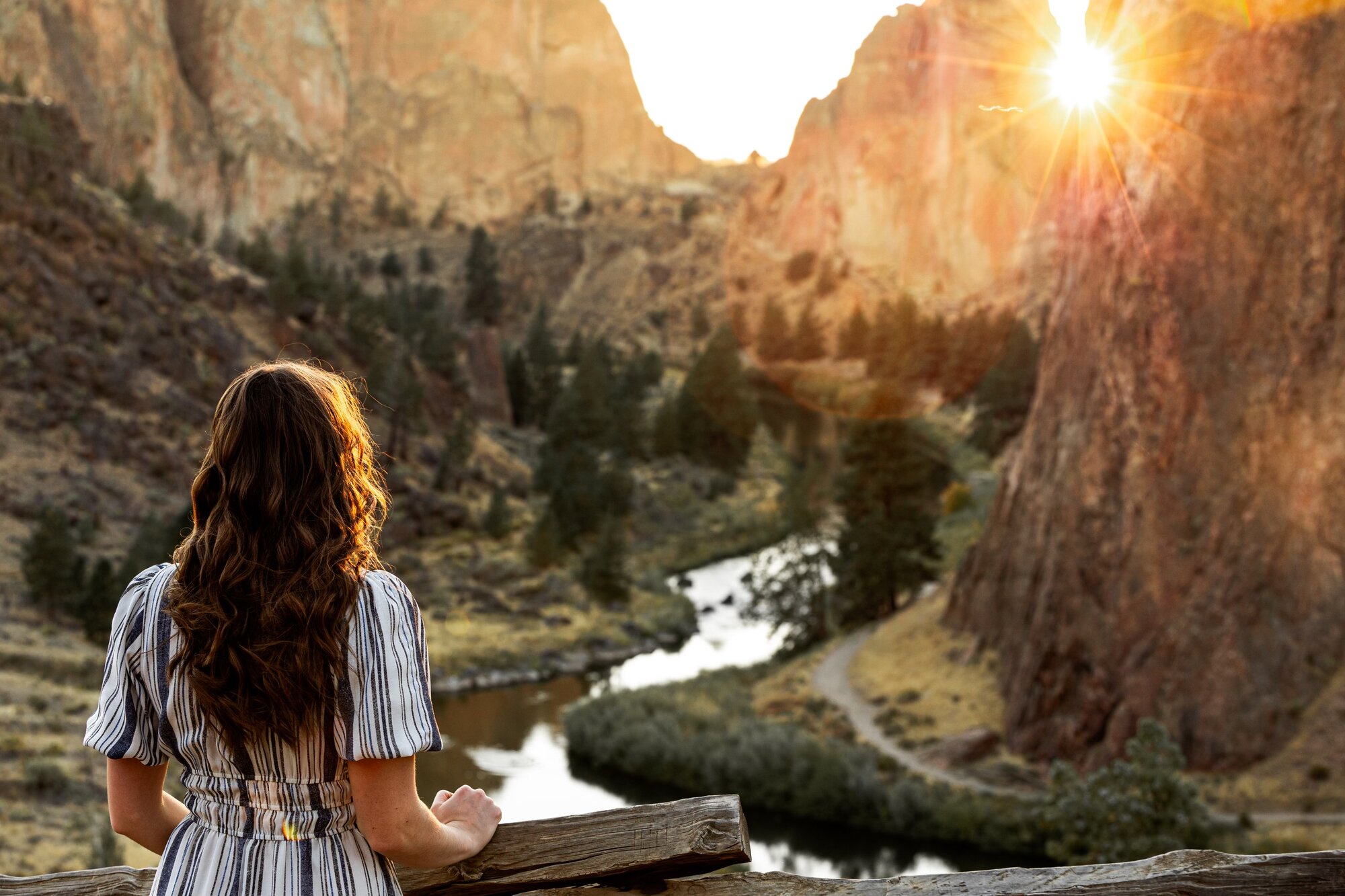 Senior girl looking out over the Crooked River canyon at sunrise, Smith Rock