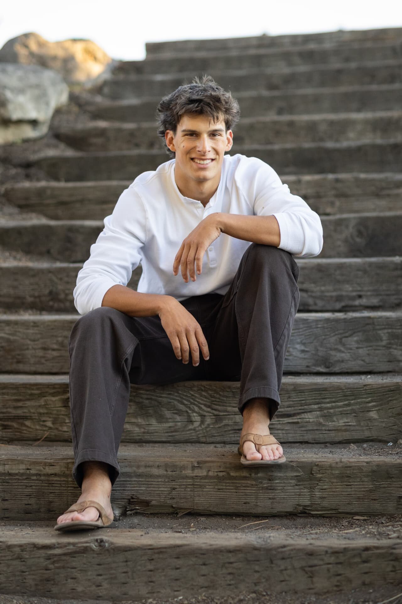 Senior guy sitting on timber steps in warm evening light
