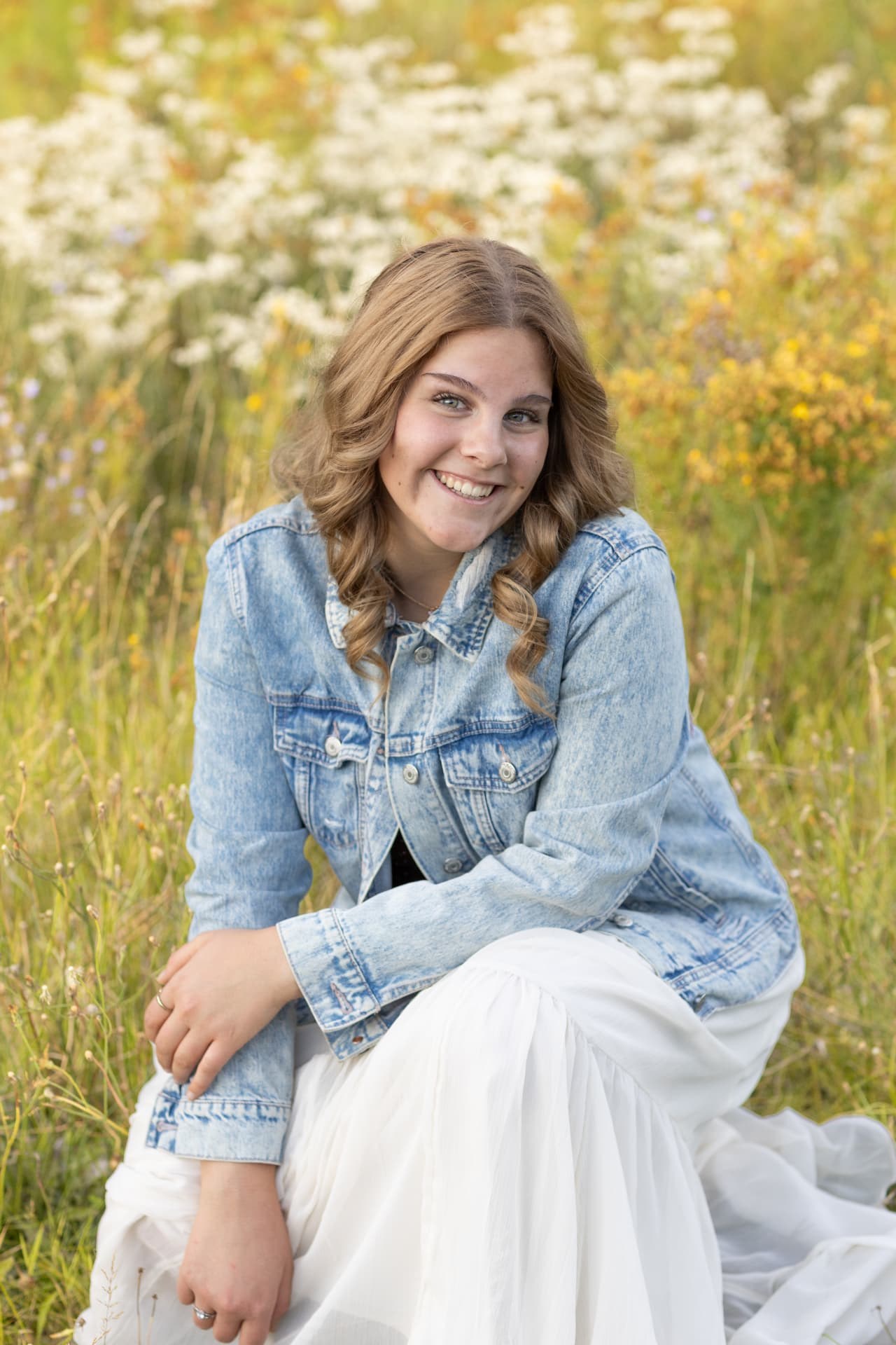 Senior girl laughing in a field of late summer wildflowers
