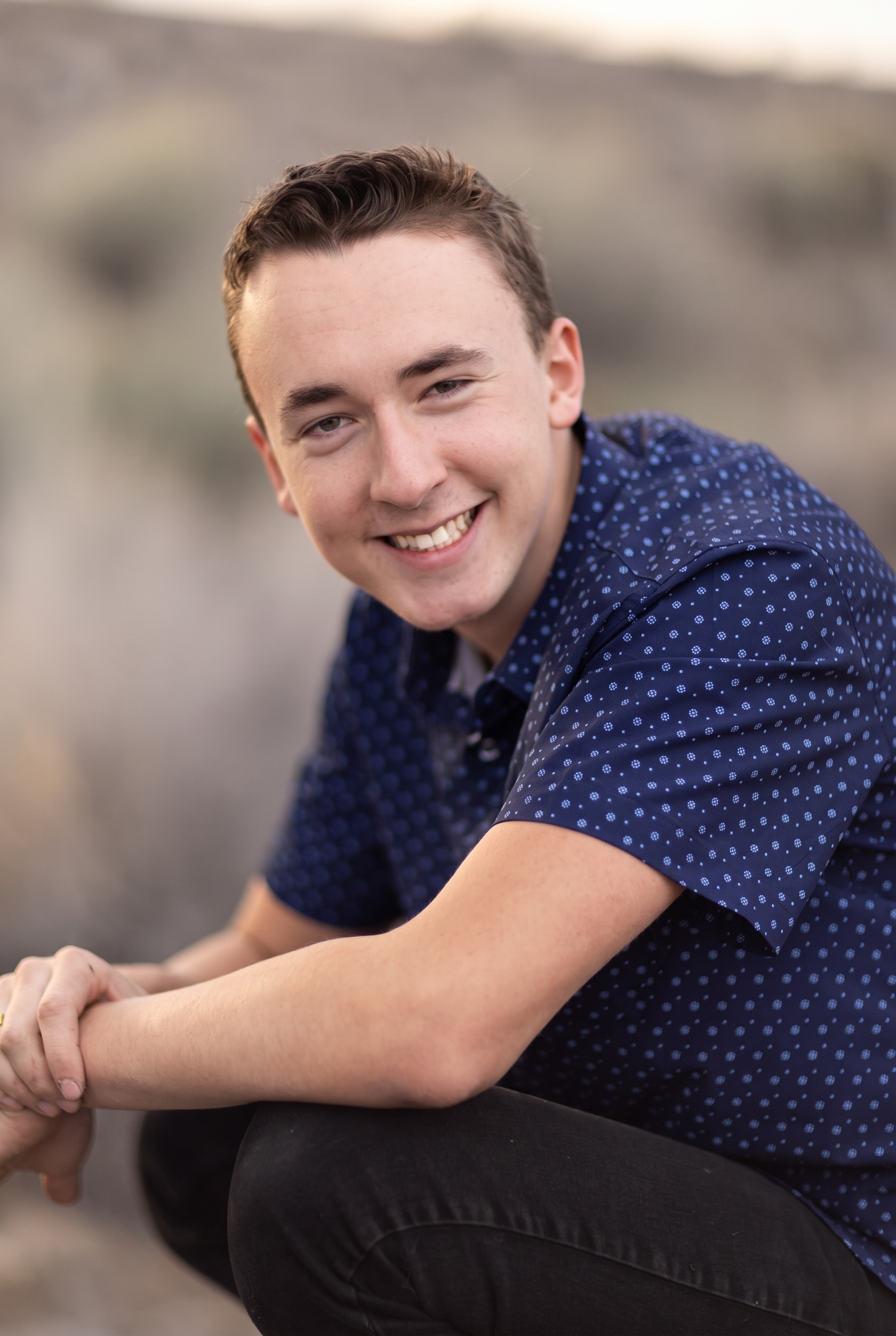 Senior guy leaning on his knee and smiling in natural light